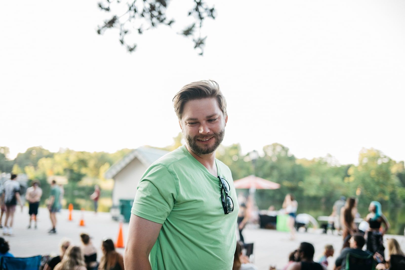 JohnLuc smiling in a green shirt at an outdoor gathering.
